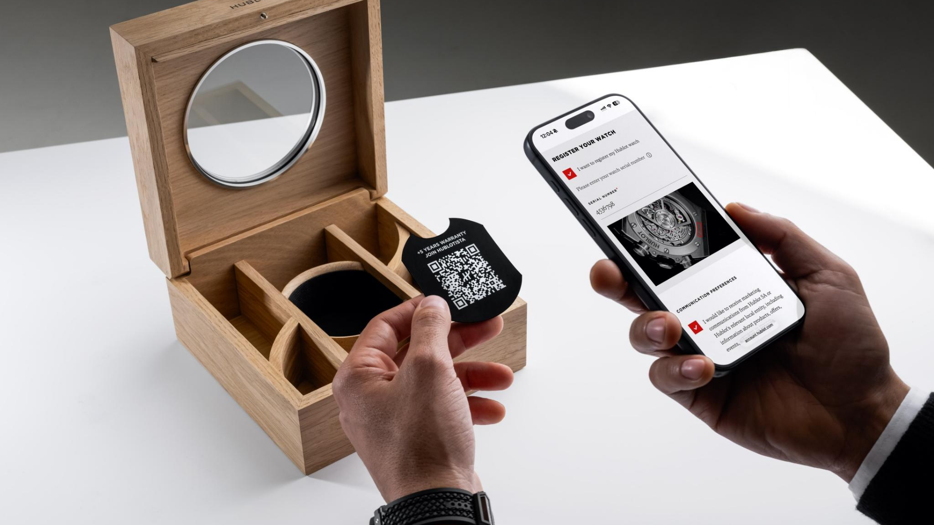 Hublot watch box with QR code card and smartphone registering luxury timepiece for extended warranty and digital verification