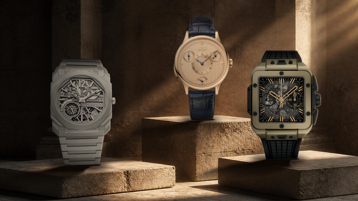 Bvlgari Octo Finissimo, Breguet Classique 7225 and Hublot Unico Magic Gold watches displayed on tiered stone plinths in a dramatic architectural setting.