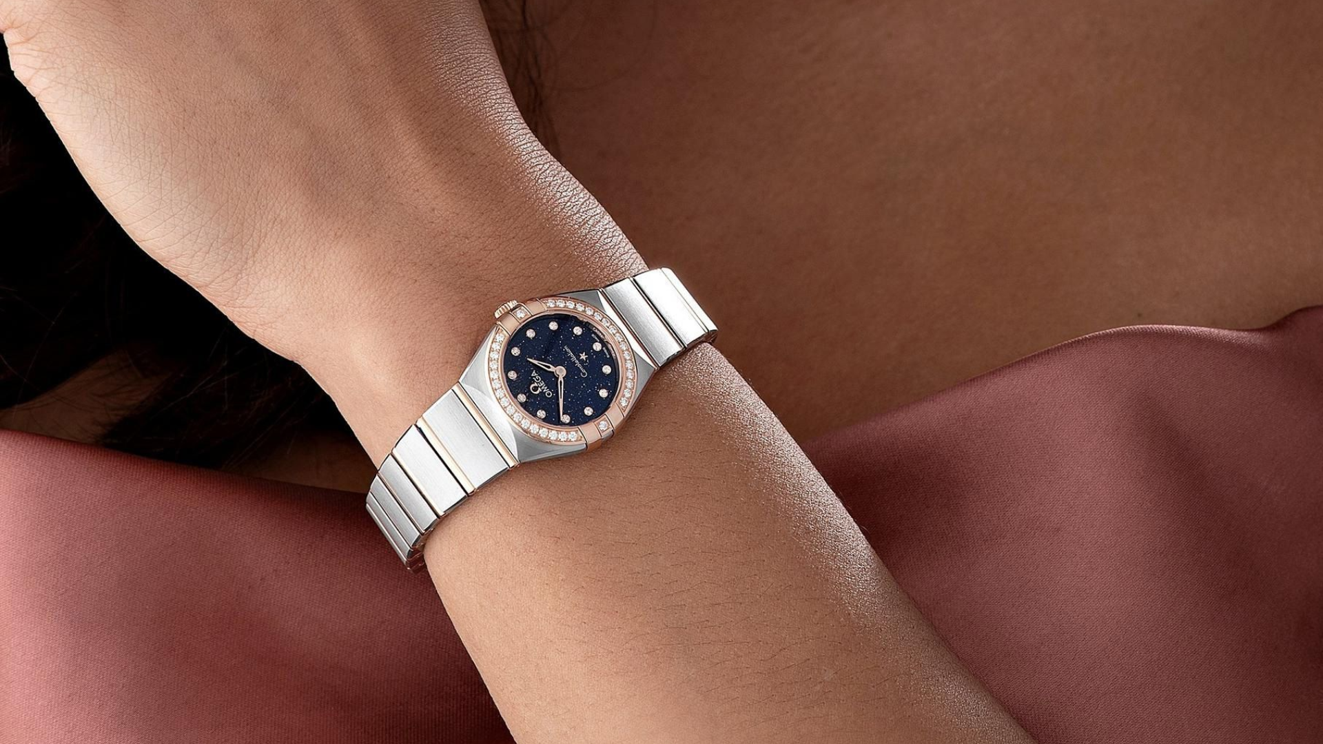 Omega Constellation women's luxury stainless steel watch with silver dial worn on the wrist