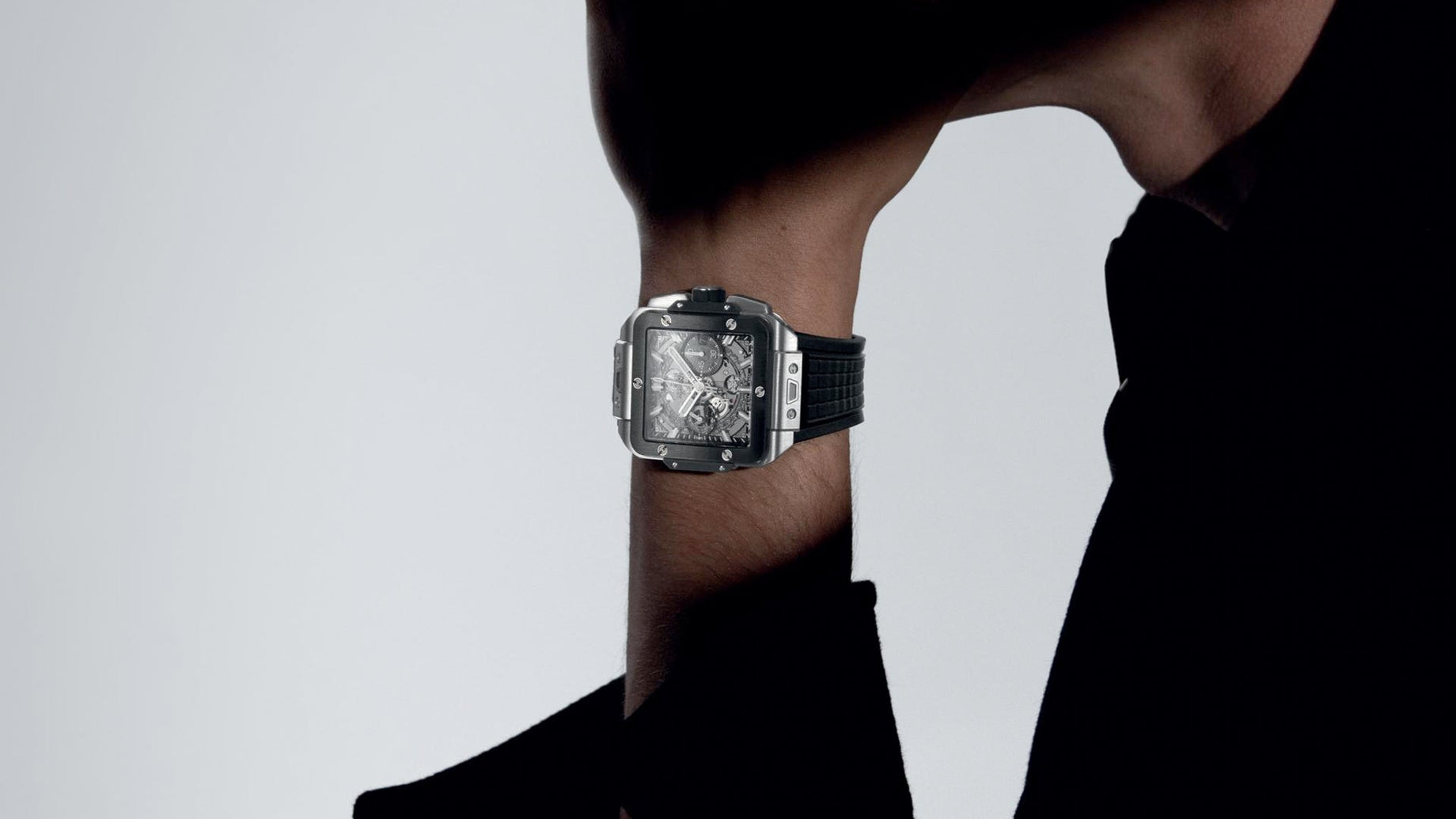  Luxury stainless steel sports watch with blue dial and rotating bezel on wrist wearing beige jacket